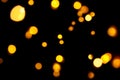 Gold bokeh on dark background. Defocused golden lights. New Year, Christmas background, abstract texture. Royalty Free Stock Photo