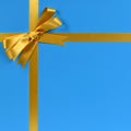 Gold bow gift ribbon blue background cross shape Royalty Free Stock Photo