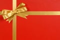 Gold bow gift ribbon red background Royalty Free Stock Photo