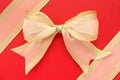 Gold bow on red background. Royalty Free Stock Photo