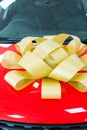 Gold bow on red car Royalty Free Stock Photo