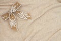 Gold bow with white snowflake on beige knit textured material background