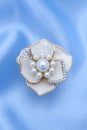 Gold brooch flower with a pearls and diamonds isolated on silk