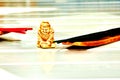 Gold buddha figurine and an incense on white table