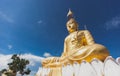 Gold Buddha Image with blue sky and scattering cloud. Royalty Free Stock Photo