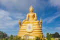 Gold Buddha Image with blue sky and scattering cloud. Royalty Free Stock Photo