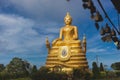 Gold Buddha Image with blue sky and scattering cloud. Royalty Free Stock Photo