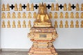 Gold buddha on many buddha wall