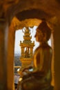 Gold Buddha statue in lotus position meditating inside golden recess