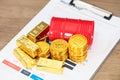 Gold bullion coins and gasoline barrel mockups on paper