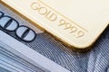 Gold bullion 999.9 fineness against the background of a hundred-dollar bills Royalty Free Stock Photo