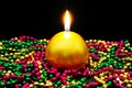 Gold candle and colourful beads.