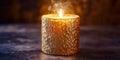 A gold candle with a flame is lit on a dark surface Royalty Free Stock Photo