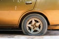 Gold car old, flat tire with rusty alloy wheel Royalty Free Stock Photo