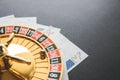 Gold casino theme. Image of casino roulette, poker games, money on the table, all on a dark bokeh background. Place for printing Royalty Free Stock Photo