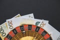 Gold casino theme. Image of casino roulette, poker games, money on the table, all on a dark bokeh background. Place for printing Royalty Free Stock Photo