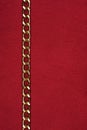 Gold chain lying on red fabric