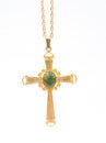 Gold Christian cross with green gem stone. Royalty Free Stock Photo