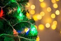Gold Christmas background of de-ocused lights garland with decorated tree Royalty Free Stock Photo