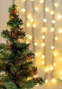 Gold Christmas background of de-ocused lights garland with decorated tree Royalty Free Stock Photo