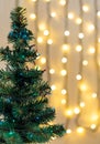 Gold Christmas background of de-ocused lights garland with decorated tree Royalty Free Stock Photo