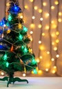 Gold Christmas background of de-ocused lights garland with decorated tree Royalty Free Stock Photo