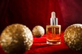 Gold christmas balls and face oil on red background Royalty Free Stock Photo