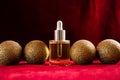 Gold christmas balls and face oil on red background Royalty Free Stock Photo