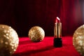 Gold christmas balls and red lipstick on red background Royalty Free Stock Photo