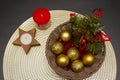 Gold Christmas decorations and red beads in a basket, two candles on a gold round napkin Royalty Free Stock Photo