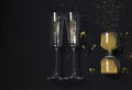 Gold christmas flat layout with confetti, two champagne glasses and hourglass on black background. New Year festive concept. Top Royalty Free Stock Photo