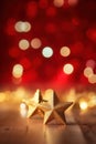 Gold christmas stars with christmas glowing golden red on a red blurred bokeh background Royalty Free Stock Photo