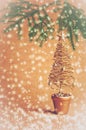 Gold Christmas tree on orange background with falling snow Royalty Free Stock Photo