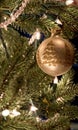 Gold christmas tree ornament with glitter tree design hanging on tree Royalty Free Stock Photo