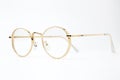 Gold classic round glasses on white background