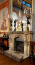 A fireplace with ornate gold clock on it reflected in a mirror in the Royal Pavilion.