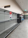 Supermarket empty toilet paper shelves amid coronavirus fears, shoppers panic buying and stockpiling toilet paper Royalty Free Stock Photo