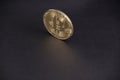 Gold coin bitcoin stands upright on black leather casts a Golden glare Royalty Free Stock Photo