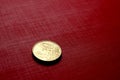 Gold coin on red surface