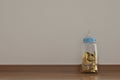 Gold coins in baby bottle on wooden floor 3D illustration. Royalty Free Stock Photo