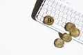 Gold coins with bitcoin symbol, lying on white computer keyboard and white table. Royalty Free Stock Photo
