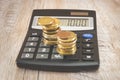 Gold coins on a calculator. Business concept. Money saving concept. Wood background.