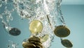 Gold coins dropped into water. Splash of coins falling into the water Royalty Free Stock Photo