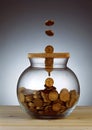 Gold coins dropping into glass jar Royalty Free Stock Photo