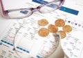 Gold coins with eyeglasses and magnifier