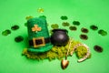 Gold coins scattered on green isolated background, St. Patricks hat, leprechaun kettle, horseshoe Royalty Free Stock Photo