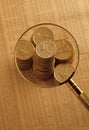 Gold coins on stock index under magnifying glass Royalty Free Stock Photo