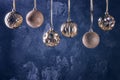 Gold-colored Christmas balls hanging by a ribbon. Beautiful composition with place for text on a black textured Royalty Free Stock Photo