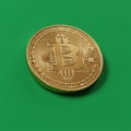 Gold-colored coin featuring the Bitcoin logo and binary code-like detailing against a Royalty Free Stock Photo