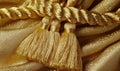 A gold colored fabric with a gold colored rope Royalty Free Stock Photo